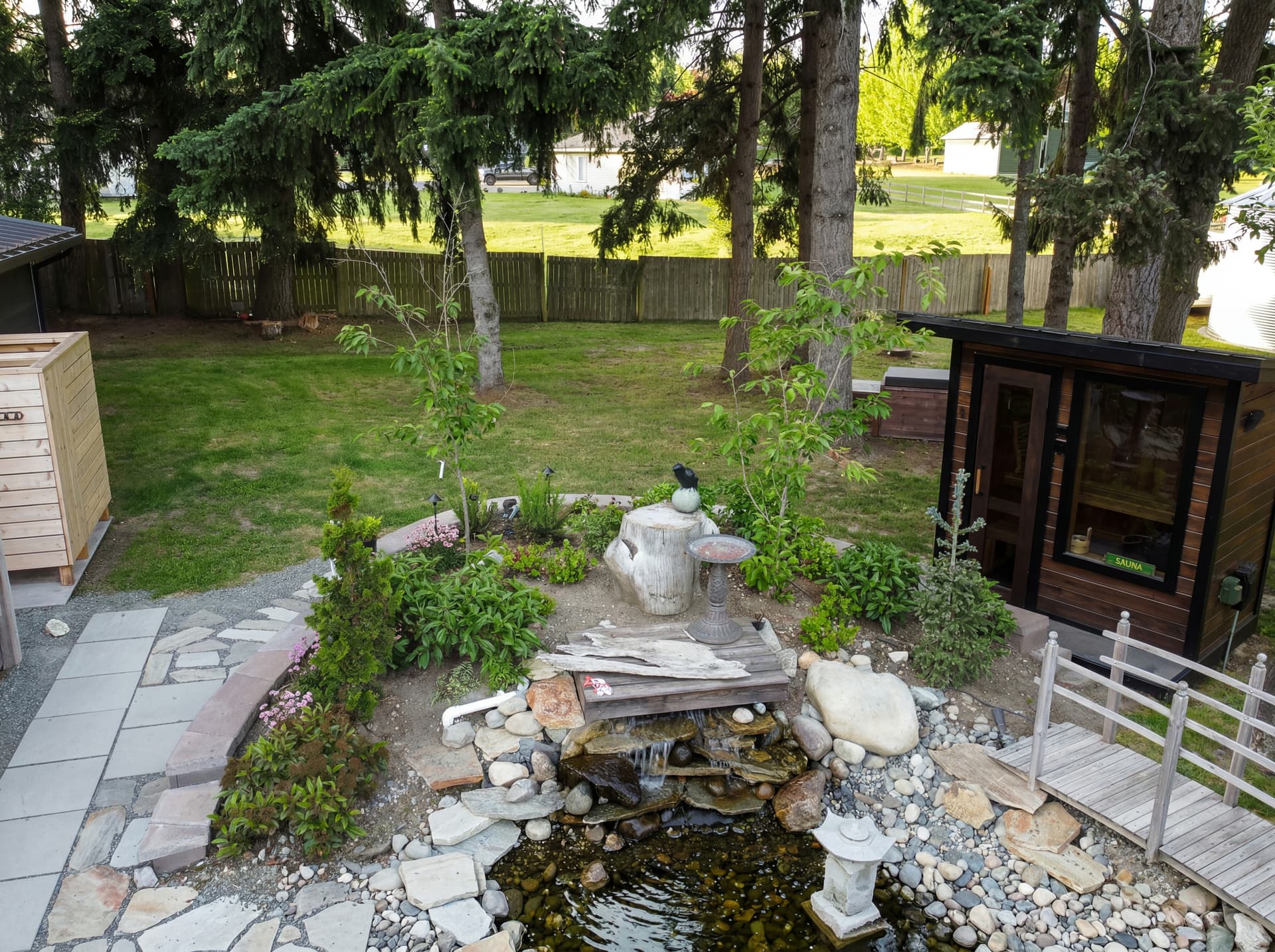 Aerial view of Yutori backyard with sauna, plunge, and cedar shower at golden hour